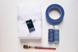 Materiais: Toalha branca, fita adesiva de 2,5 cm a 3 cm de largura, pincel, e tinta para tecidos (no caso azul navy).