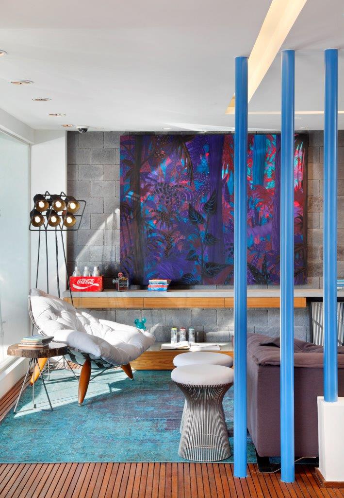 Sofá Da Vila assinado por Cláudio Ziegler, poltrona Moleco assinada pela Lattoog Design, mesa de centro Box (encostada na parede) assinada por Marcelo Ligieri, quadro Toz da Galeria Movimento, tapete da Casa Júlio, luminária de piso italiana Multilamp, fotografias (apoiadas no chão) de Guilia Paulinelli, tela “Floresta Noturna” do artista Toz, banquetas Platner assinadas por Warren Platner em 1919, mesa de apoio pastilha (tampo em madeira bruta) assinada por Leonardo Bueno, escultura de parede laranja assinada por Melão, tapete da Casa Júlio.